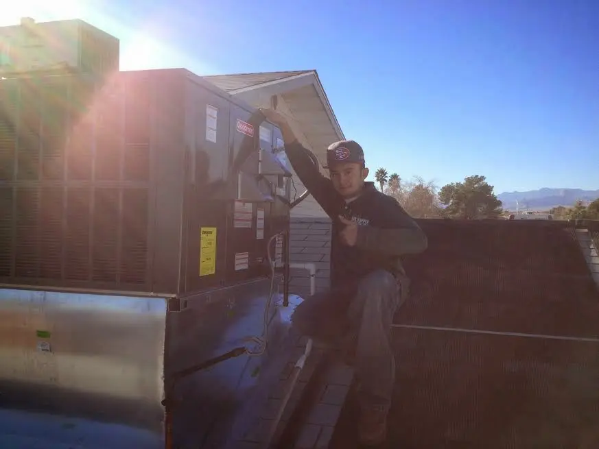 HVAC technician performing Boiler Repair on a rooftop unit in North Bend